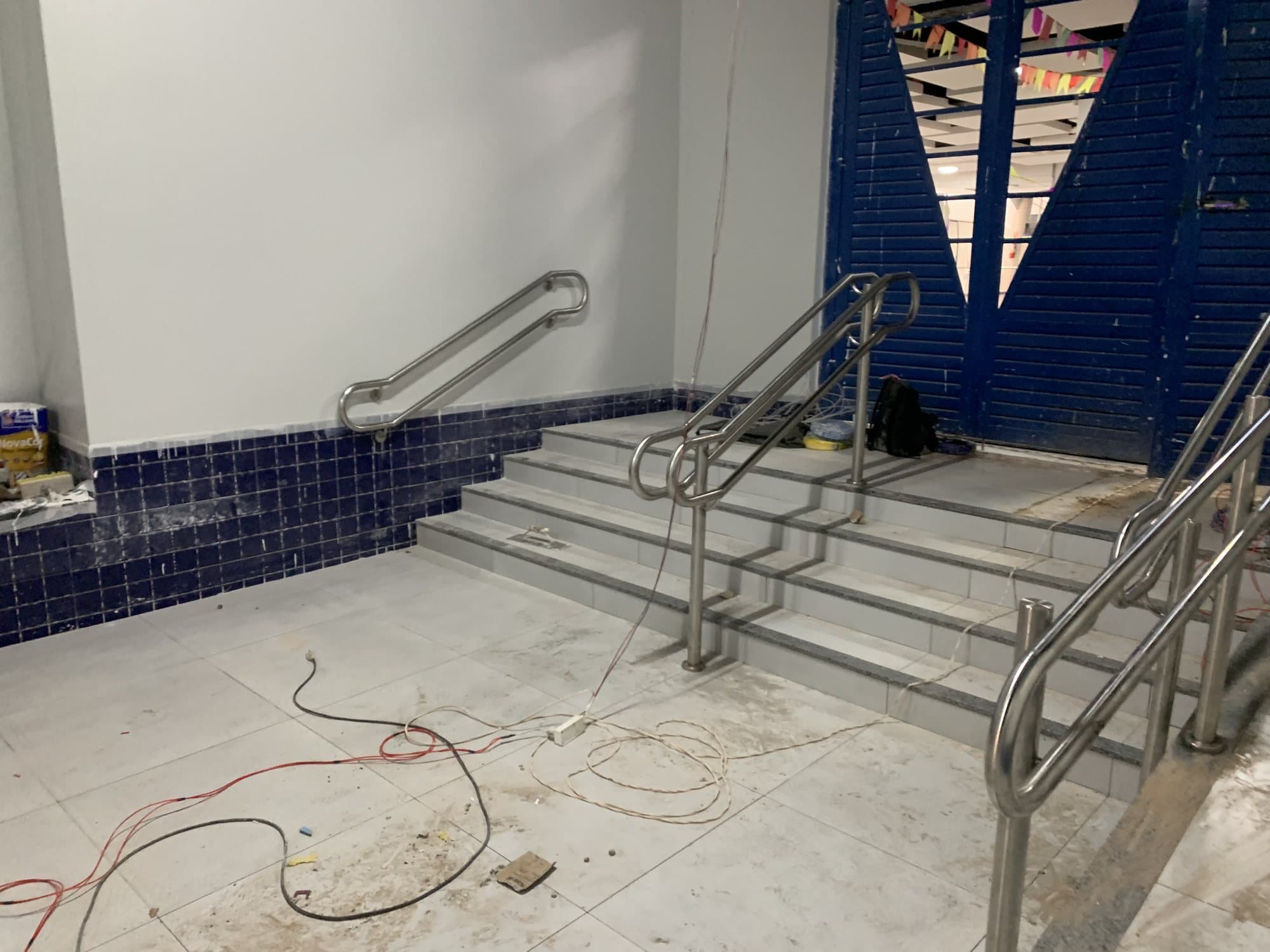 Corrimãos em aço inox na parede e nas laterais da escada de acesso