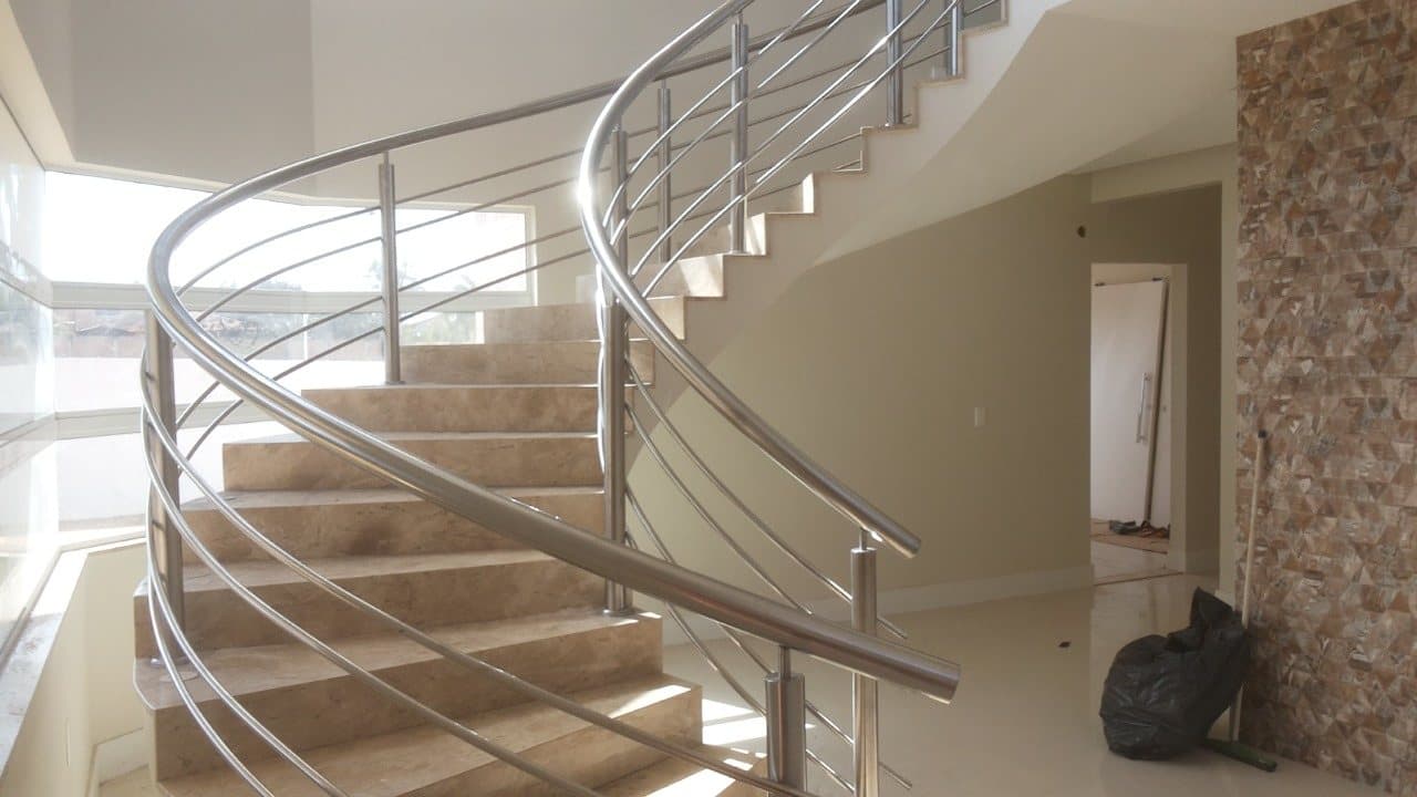 Vista frontal da escada curva com guarda-corpo em aço inox dos dois lados