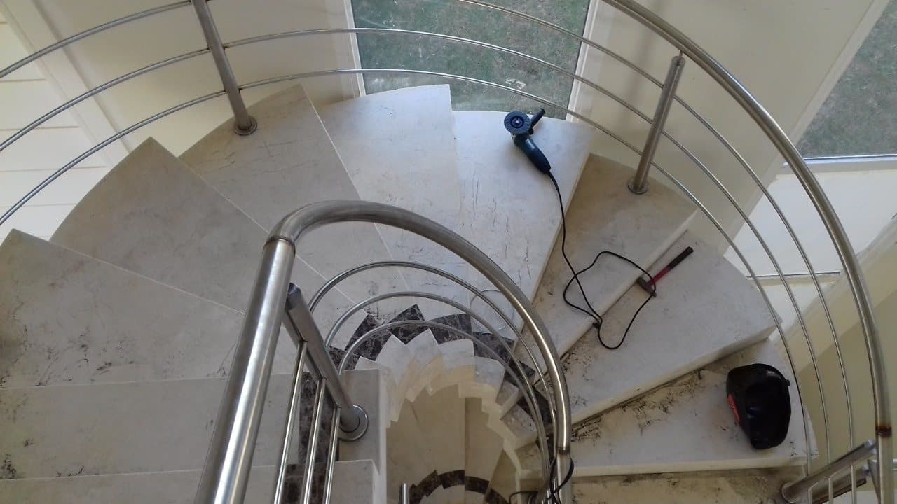 Vista de cima da escada helicoidal com corrimão e tubos curvados em aço inox