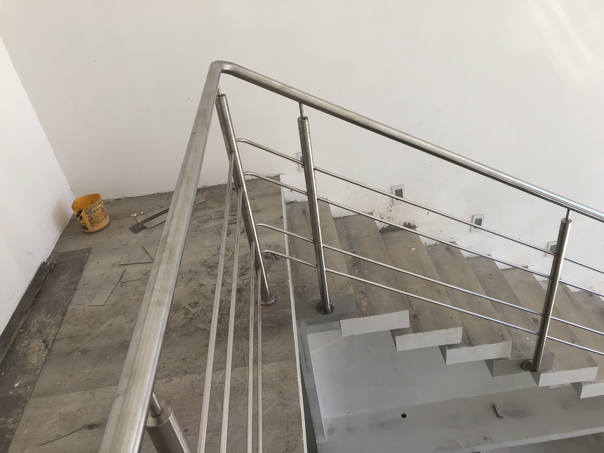 Guarda-corpo em aço inox com longarinas horizontais no topo de uma escada de mármore