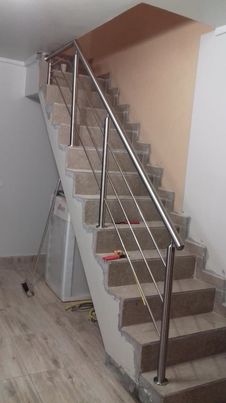 Escada reta de granito com guarda-corpo em aço inox de longarinas inclinadas