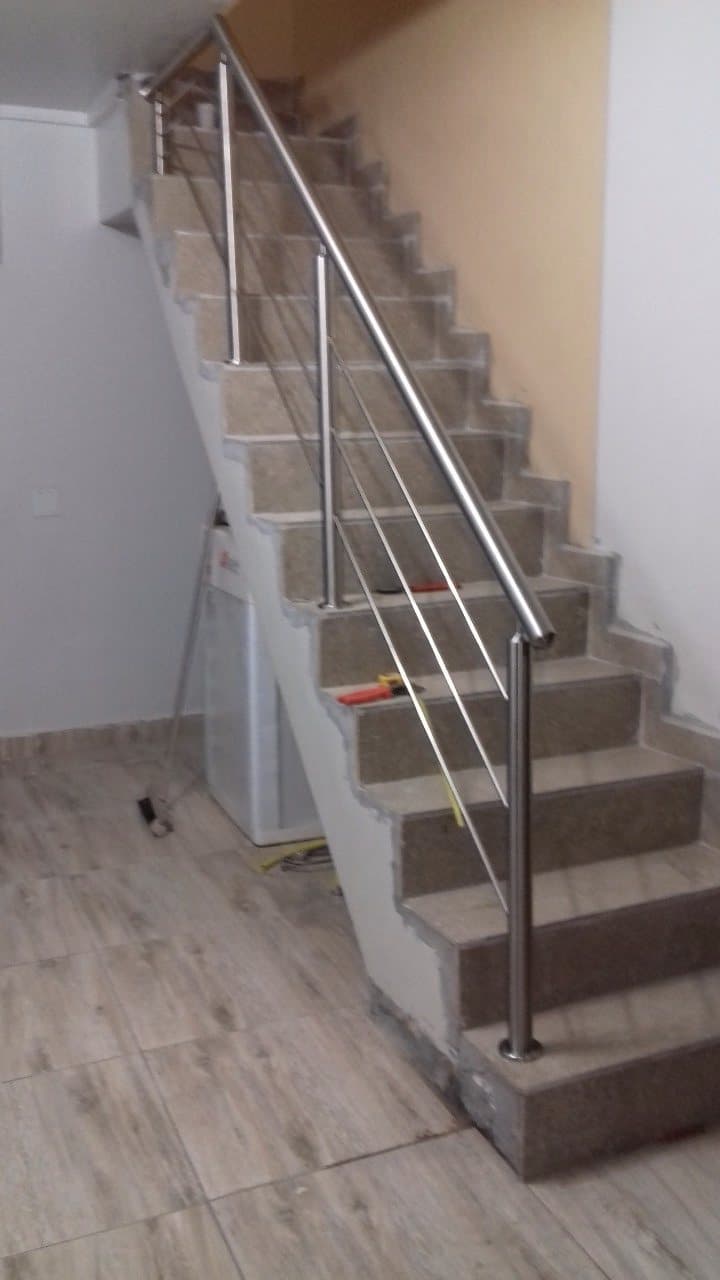 Vista frontal da escada reta com guarda-corpo em aço inox
