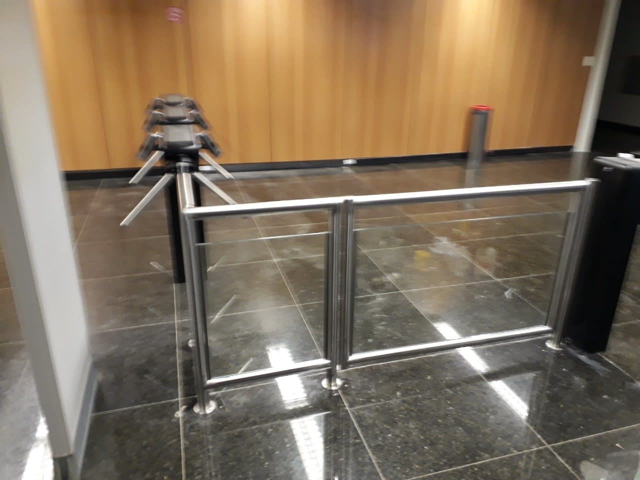 Guarda-corpo em aço inox com dois painéis de vidro diante das catracas