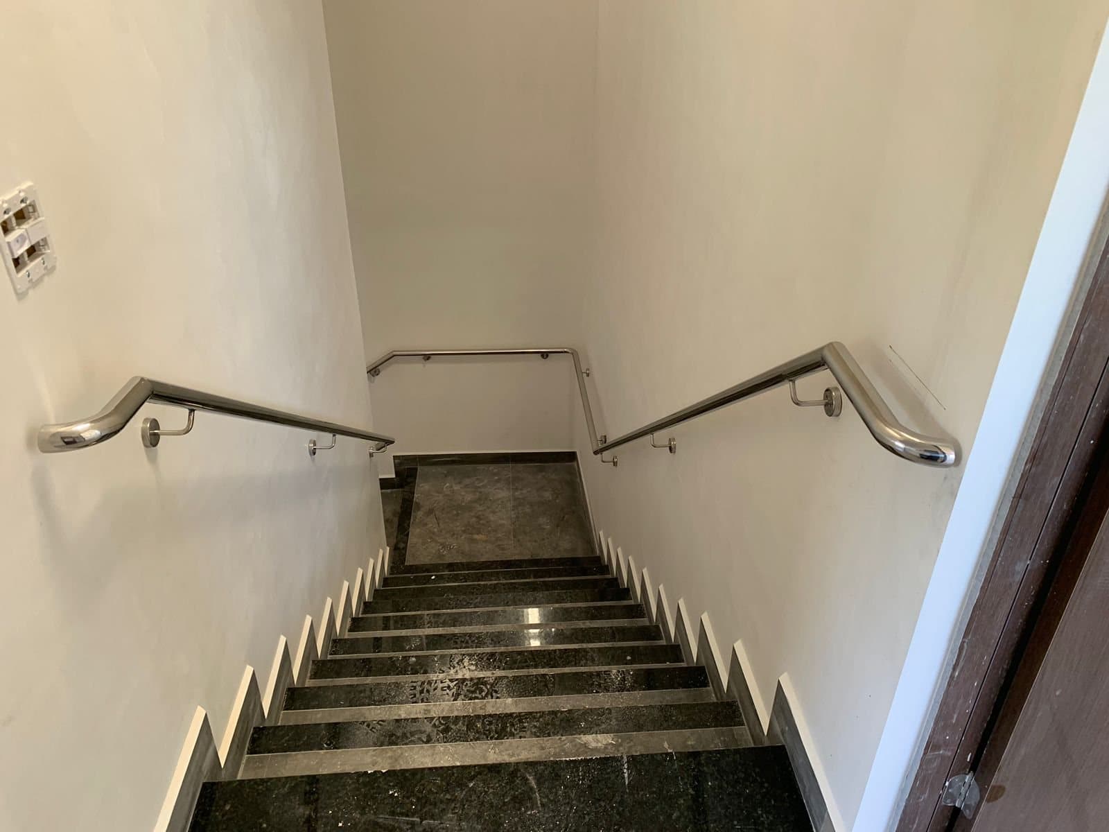 Corrimãos de parede em aço inox vistos do topo da escada
