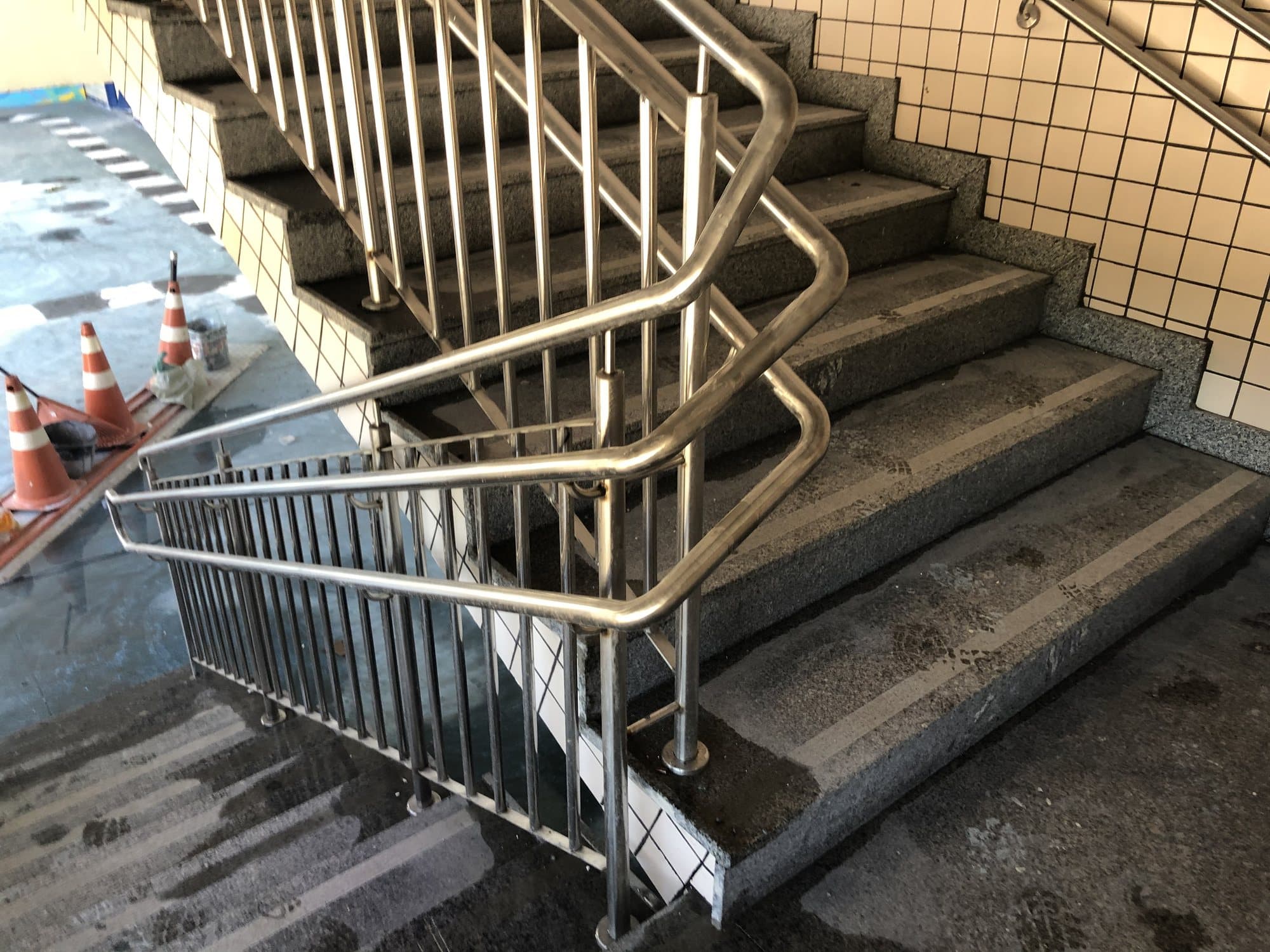 Detalhe da curva do corrimão duplo em aço inox no patamar da escada